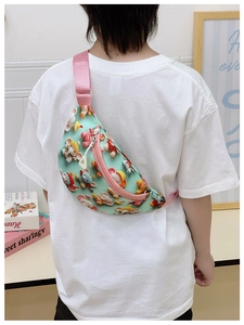 Vue arrière d'un enfant portant un sac de poitrine éléphant vert clair avec sangle rose