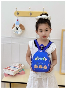 Detail of blue kids' backpack featuring cute capybara illustrations and HONEY letter patch