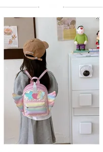 Detail of pink quilted toddler backpack featuring rainbow sequin wings and heart patches