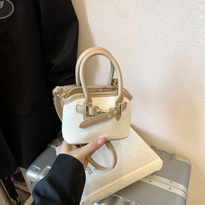 Detail of mini canvas and leather handbag featuring retro gold horsebit hardware detail