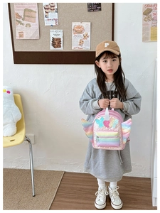 Pink quilted unicorn backpack for girls with sequin stars and rainbow wings on model