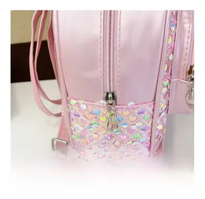 Gros plan du sac à dos rose à paillettes montrant le zip en métal et les coutures