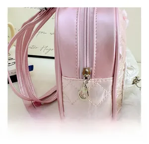 Detailed side view of quilted pink kids backpack with tulip zipper and white fluffy ball pom