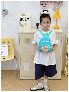 Sky blue kids backpack with sleeping capybara illustration on a young model's back