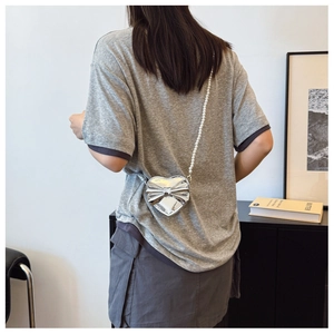 Silver heart-shaped girl's crossbody bag featuring a 3D bow and elegant pearl strap
