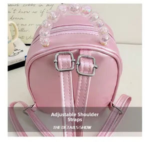 Detail of pink PU leather kids backpack featuring adjustable straps and beaded handle
