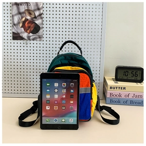 Detail view of mini multi-color nylon kids backpack with tablet for size reference