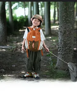 Détail extérieur du sac à dos enfant bicolore avec étiquette MOUNTAINS et poches à cordon