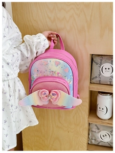 Detail view of pink sequin kids backpack with rainbow wings and glitter heart pocket