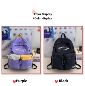 Detail view of large capacity nylon school backpacks in purple and black colorways