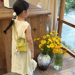Lime green mini shell crossbody bag for kids with cute doll pendant and pearl strap