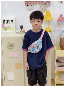 Détail d'un sac bandoulière enfant bleu à imprimé éléphant et sangle rose vif