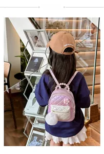 Detail of pink laser backpack with quilted texture, pearl handle and fur pompom