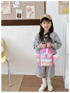 Pink unicorn backpack for girls with glitter bow and rainbow wings on a young model