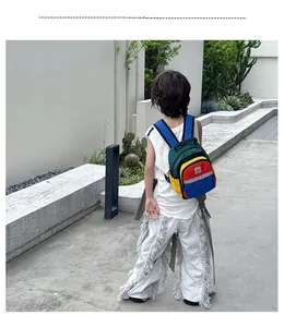Detail of color-block kids backpack with reflective strip and front zipper pocket