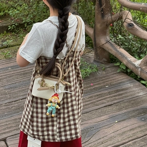 Kids mini crossbody shell bag with cute doll pendant on cream canvas and brown leather