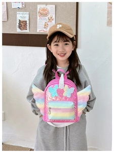 Detail of pink unicorn backpack with glitter wings and heart sequin worn by a little girl
