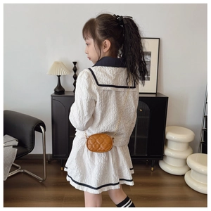 Dettaglio di una mini borsa a tracolla trapuntata a cuore marrone per bambini