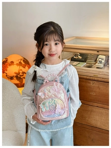 Pink sequin toddler backpack with pearl handle and butterfly lace detail on a child