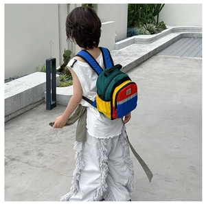 Detailed view of child modeling a colorful multi-color patchwork backpack in outdoors