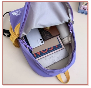 Open view showing large interior capacity of purple and yellow kids canvas backpack