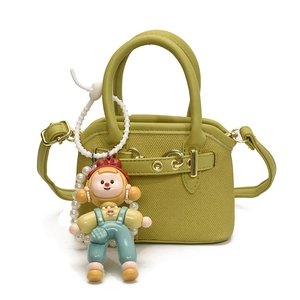 Cute mustard green mini handbag for kids with a cartoon character charm and gold hardware