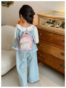 Pink sequin children backpack with 3D butterfly and pearl handle worn by a girl