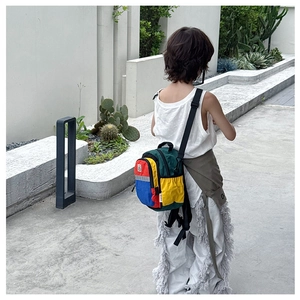 Detail of colorful patchwork kid backpack with safety reflective strip and mesh side pocket