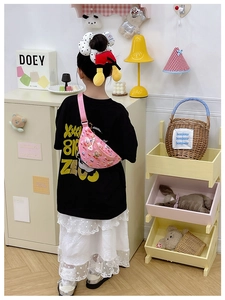 Détail du sac de poitrine rose pour enfant avec ours en 3D porté par une fille