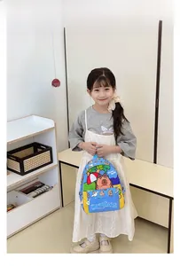 Blue kids capybara backpack with yellow pockets shown on a model for scale and fit