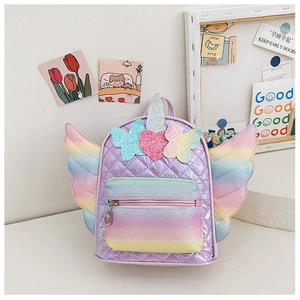 Detail view of unicorn kids backpack with rainbow wings and purple quilted fabric