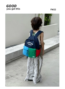 Close-up of children's color-block backpack with multi-pocket design and letter patterns