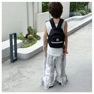 Black kids backpack with safety reflective strip shown on a model in an outdoor setting