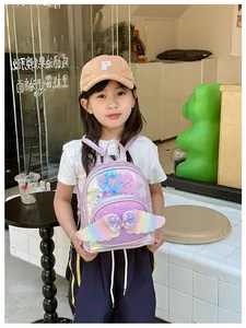 Close-up of cute purple sequin backpack with 3D wings and bow for little girls