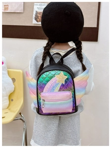 Zaino per bambini con sfumatura arcobaleno e ali colorate indossato da un modello