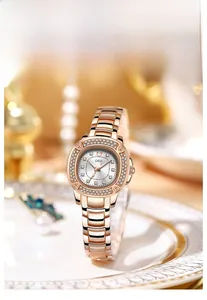 Close-up of rose gold watch with crystal bezel on a white plate in warm lighting