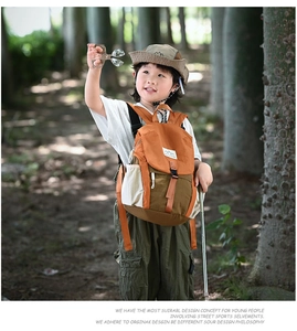 Détail d'un sac à dos d'extérieur pour enfants avec écusson montagne dans un décor de forêt