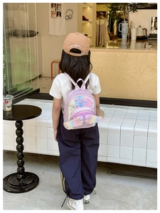 Rear view of child wearing purple sequin backpack with colorful wings and bow detail