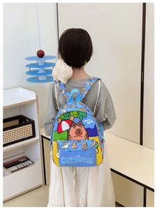 Rear view of a child wearing the cute blue and yellow Capybara printed backpack in a room
