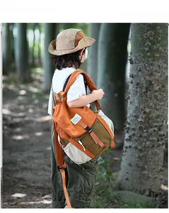 Vue extérieure d'un enfant portant le sac à dos bicolore avec étiquette Mountains