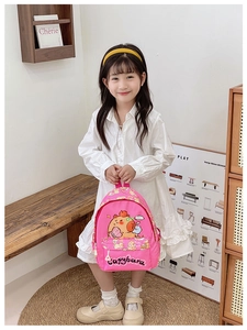 Detailed view of pink children backpack featuring a cute cartoon capybara print design
