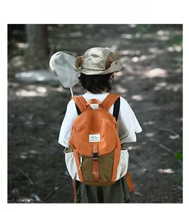 Vue arrière d'un enfant portant un sac à dos de randonnée coloré en nylon imperméable