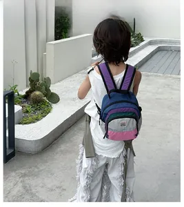 Detail view of colorful patchwork kids backpack with wide padded straps in outdoor setting