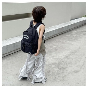 Detail view of large black school backpack with white letters and embroidery