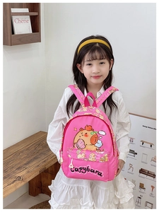 Pink girls capybara backpack shown on model in a cozy indoor lifestyle scene