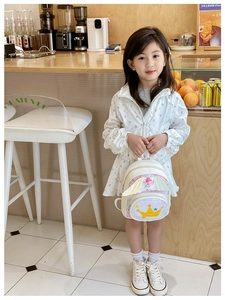 Détail d'un petit sac à dos blanc pour fille avec ailes et motif de couronne