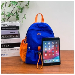 Detail of blue and orange nylon kids backpack with drawstring pocket and AN embroidery