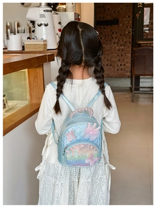 Detail of colorful sequined kids backpack with pearl handle and pink bow decor
