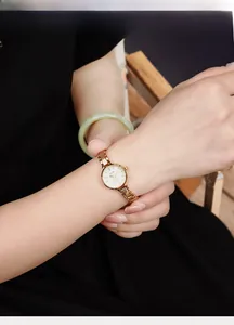 Close-up of elegant rose gold bracelet watch with a minimalist round dial on a woman's wrist