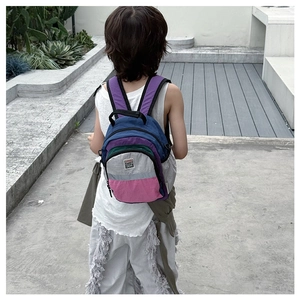 Detail view of colorful patchwork kid backpack with Fashion Sweet Bear patch on outdoor model